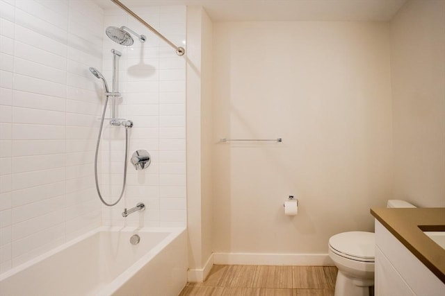 full bathroom featuring tiled shower / bath, vanity, and toilet