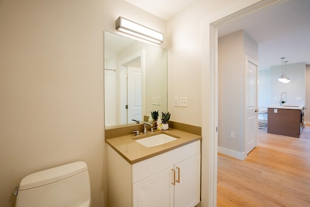 bathroom featuring vanity, hardwood / wood-style flooring, and toilet