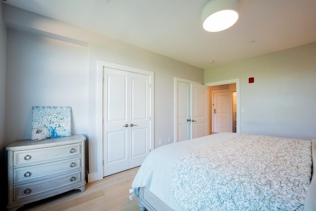 bedroom with two closets and light wood-type flooring