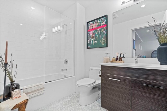 full bathroom with tile patterned flooring, toilet, tiled shower / bath combo, and vanity