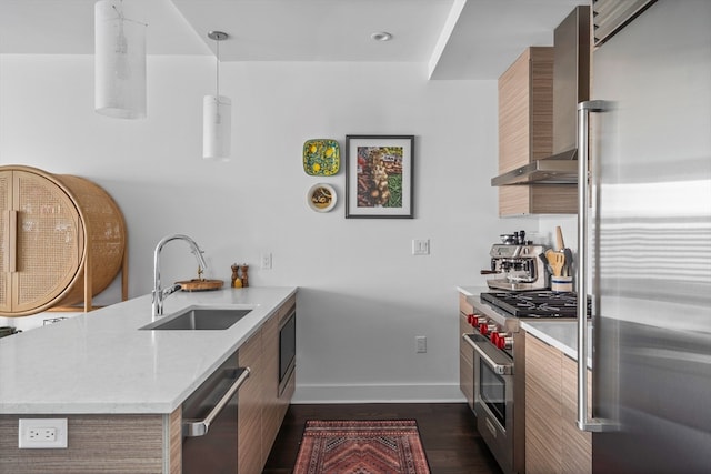 kitchen featuring decorative light fixtures, sink, wall chimney exhaust hood, kitchen peninsula, and high quality appliances