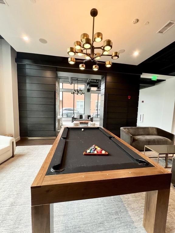 99 Sumner St Unit 307, Boston, MA 02128 - game room with a chandelier, billiards, baseboards, carpet floors, and wooden walls