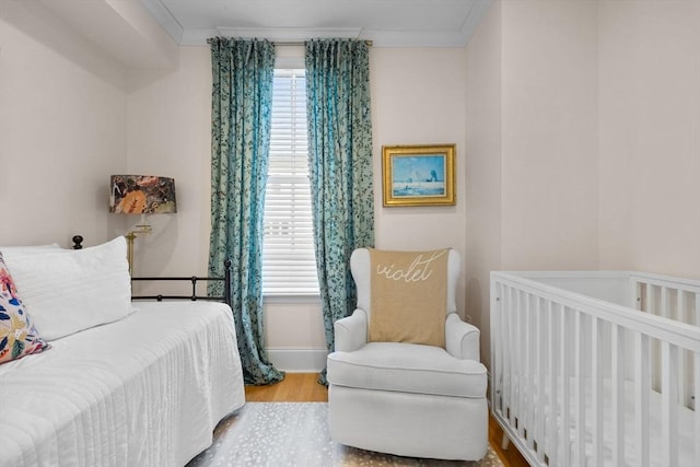 bedroom featuring wood finished floors and crown molding