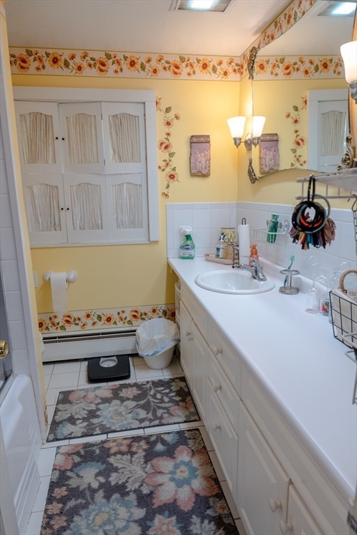 bathroom featuring tile patterned flooring, vanity, and a baseboard heating unit