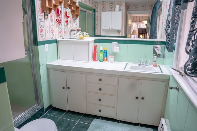 bathroom featuring tile patterned floors, vanity, a baseboard radiator, toilet, and a shower with shower door