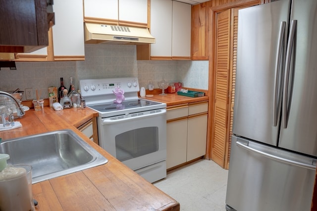 kitchen featuring stainless steel fridge, tasteful backsplash, white electric range oven, sink, and white cabinetry