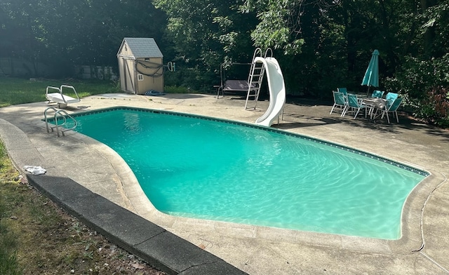 view of swimming pool with a patio and a water slide