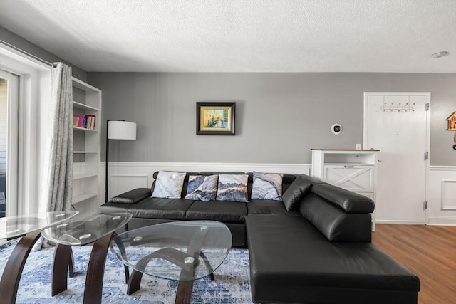 2012 Franklin Crossing Rd Unit 2012, Franklin, MA 02038 - living area with a textured ceiling, wood finished floors, and wainscoting