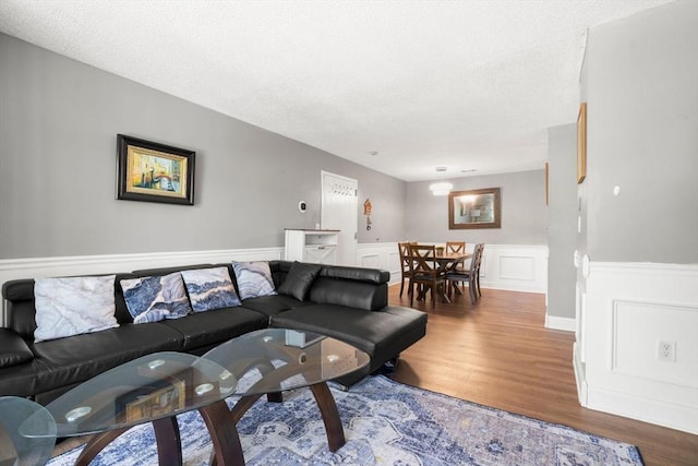 2012 Franklin Crossing Rd Unit 2012, Franklin, MA 02038 - living room with wood finished floors, wainscoting, a textured ceiling, and a decorative wall