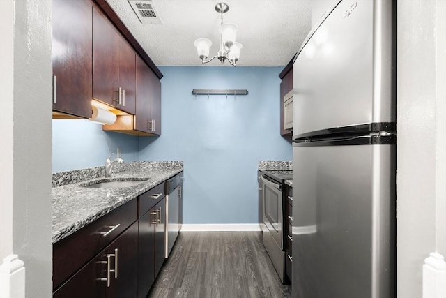 2012 Franklin Crossing Rd Unit 2012, Franklin, MA 02038 - kitchen featuring stainless steel appliances, dark wood-style flooring, light stone counters, hanging light fixtures, and a chandelier