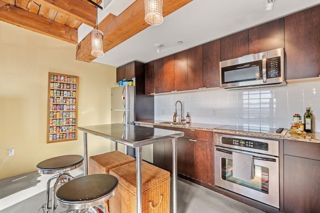 kitchen featuring backsplash, light stone countertops, stainless steel appliances, and beamed ceiling