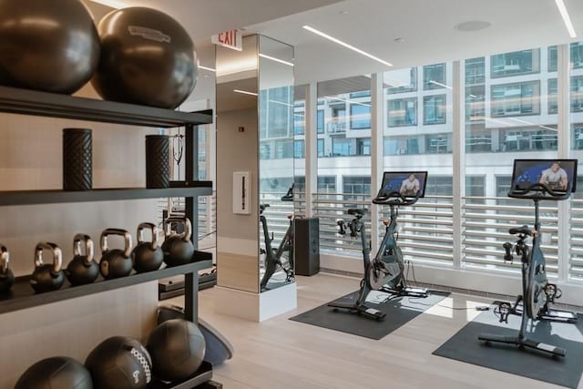 exercise room with light wood-type flooring