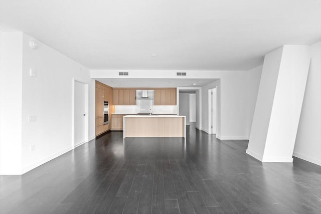 unfurnished living room featuring dark wood-type flooring and sink