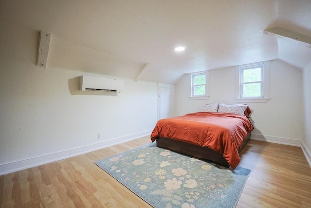 268 Wallace Hill Rd, Townsend, MA 01469 - bedroom with an AC wall unit, wood finished floors, baseboards, and vaulted ceiling