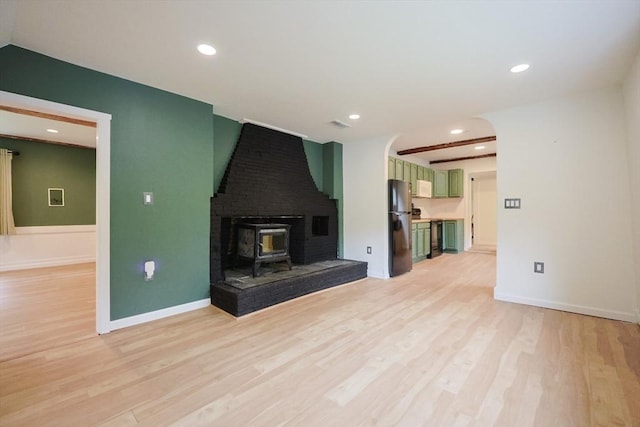 268 Wallace Hill Rd, Townsend, MA 01469 - unfurnished living room with light wood-style floors, recessed lighting, a wood stove, and baseboards