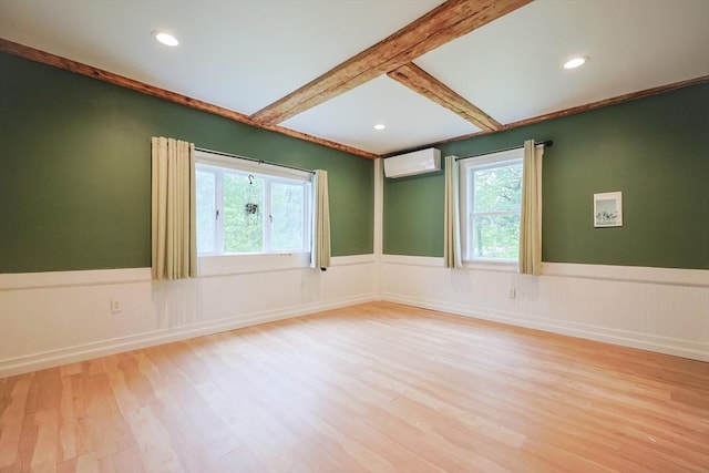 268 Wallace Hill Rd, Townsend, MA 01469 - empty room with wood finished floors, a wainscoted wall, healthy amount of natural light, a wall unit AC, and beamed ceiling