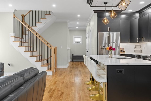 33 Peirce St Unit 1, Waltham, MA 02453 - kitchen featuring dark cabinets, ornamental molding, open floor plan, high end refrigerator, and light wood finished floors