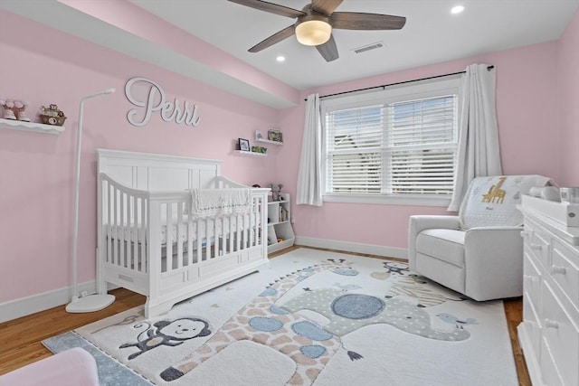 33 Peirce St Unit 1, Waltham, MA 02453 - bedroom featuring a crib, visible vents, baseboards, and wood finished floors