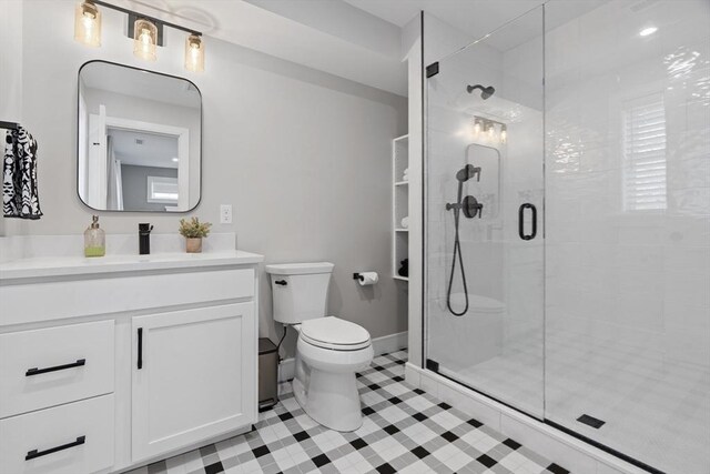 33 Peirce St Unit 1, Waltham, MA 02453 - full bath featuring a shower stall, vanity, tile patterned flooring, toilet, and baseboards