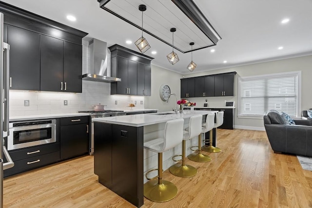 33 Peirce St Unit 1, Waltham, MA 02453 - kitchen with wall chimney range hood, light countertops, a sink, and dark cabinetry