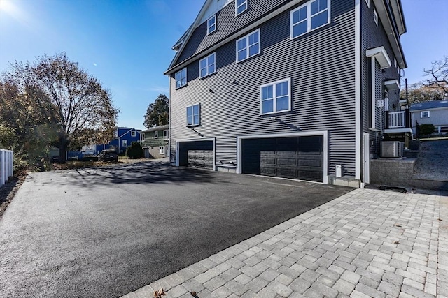 33 Peirce St Unit 1, Waltham, MA 02453 - view of property exterior with central AC, an attached garage, and aphalt driveway