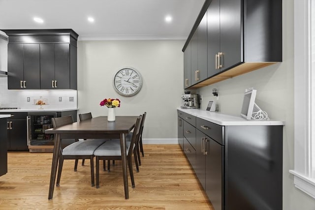 33 Peirce St Unit 1, Waltham, MA 02453 - kitchen with dark cabinets, light countertops, light wood finished floors, wine cooler, and decorative backsplash