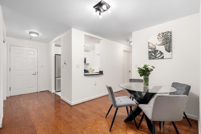 dining space featuring wood finished floors and baseboards