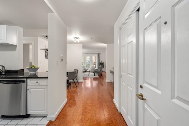hall featuring light wood finished floors and baseboards