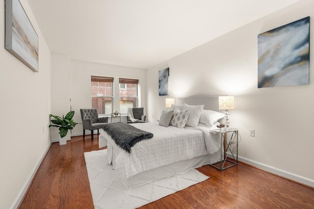 bedroom with baseboards and wood finished floors