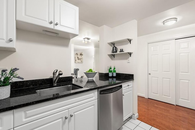 kitchen with dishwasher, a sink, and white cabinetry