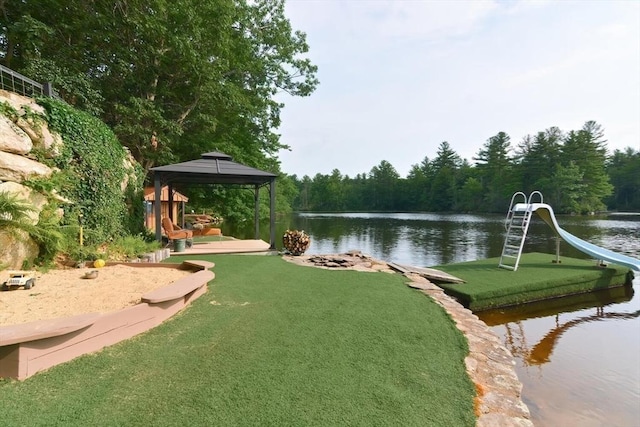 exterior space featuring a gazebo, a lawn, and a water view