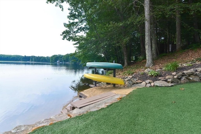 dock area with a lawn and a water view