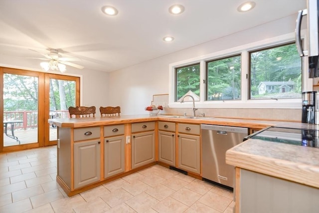 kitchen with dishwasher, kitchen peninsula, plenty of natural light, and sink