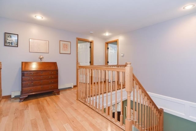 corridor featuring light hardwood / wood-style flooring and a baseboard heating unit