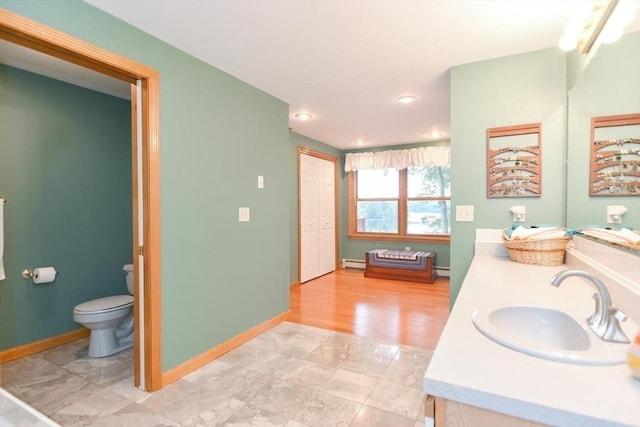 bathroom with vanity, a baseboard radiator, toilet, and hardwood / wood-style flooring