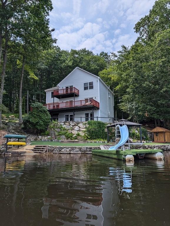 rear view of house featuring a water view and a balcony