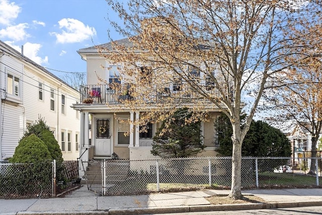 136-138 N St, Somerville, MA 02144 - view of front of home with a gate, stucco siding, a fenced front yard, and a balcony