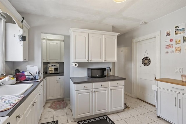 136-138 N St, Somerville, MA 02144 - kitchen featuring a sink, white cabinets, light tile patterned floors, and black microwave