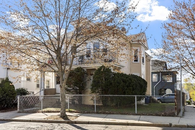 136-138 N St, Somerville, MA 02144 - view of front of property with a fenced front yard, a balcony, and stucco siding