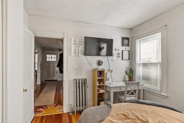 136-138 N St, Somerville, MA 02144 - bedroom featuring radiator heating unit, multiple windows, and wood finished floors