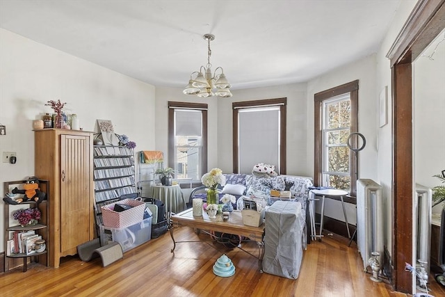 136-138 N St, Somerville, MA 02144 - living area with a chandelier, wood finished floors, and radiator