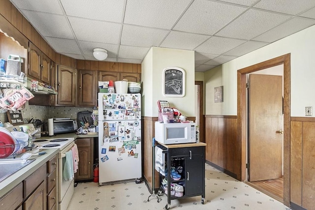 136-138 N St, Somerville, MA 02144 - kitchen featuring white appliances, wood walls, a wainscoted wall, a drop ceiling, and light floors