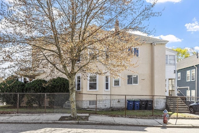 136-138 N St, Somerville, MA 02144 - view of property exterior featuring a fenced front yard and stucco siding