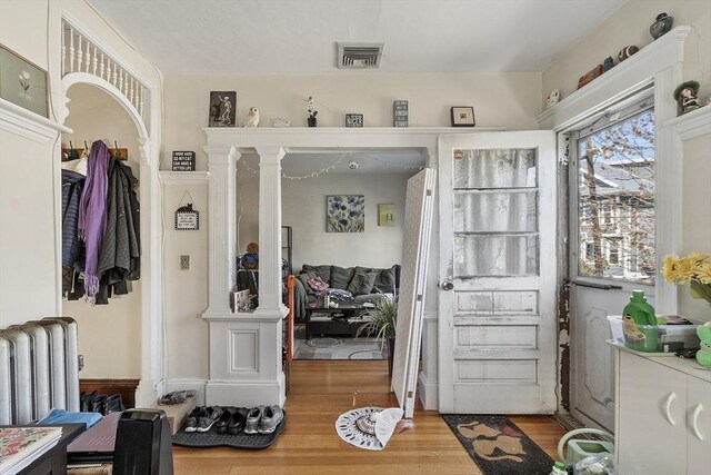136-138 N St, Somerville, MA 02144 - doorway featuring decorative columns, visible vents, wood finished floors, and radiator