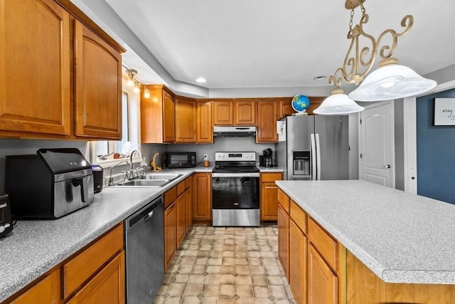 230 Plain, Taunton, MA 02780 - kitchen with stainless steel appliances, under cabinet range hood, a sink, brown cabinetry, and light countertops
