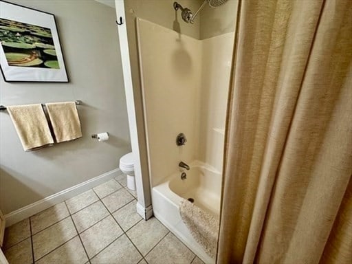 bathroom with tile patterned floors, toilet, and shower / tub combo