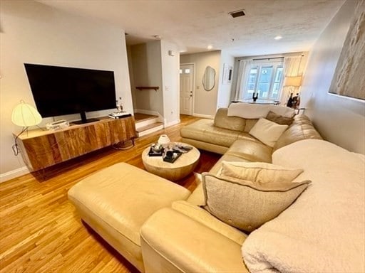 living room with hardwood / wood-style floors and a textured ceiling