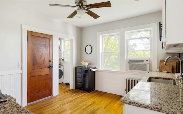 67 Jamaica Unit 3, Boston, MA 02130 - entrance foyer with radiator, washer / clothes dryer, light wood-style floors, a wainscoted wall, and a ceiling fan