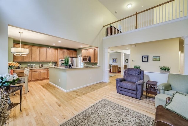 living room with light hardwood / wood-style flooring and ornate columns