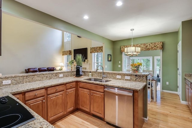 kitchen featuring sink, hanging light fixtures, light stone countertops, black electric cooktop, and stainless steel dishwasher